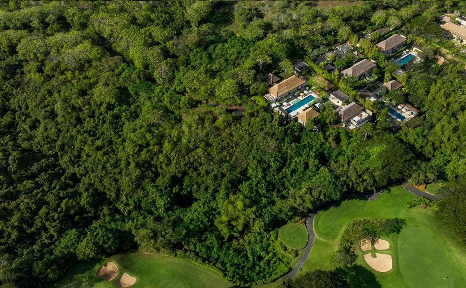 Aerial view of Aman Villas at Nusa Dua: pool villas in dense forest above the golf course