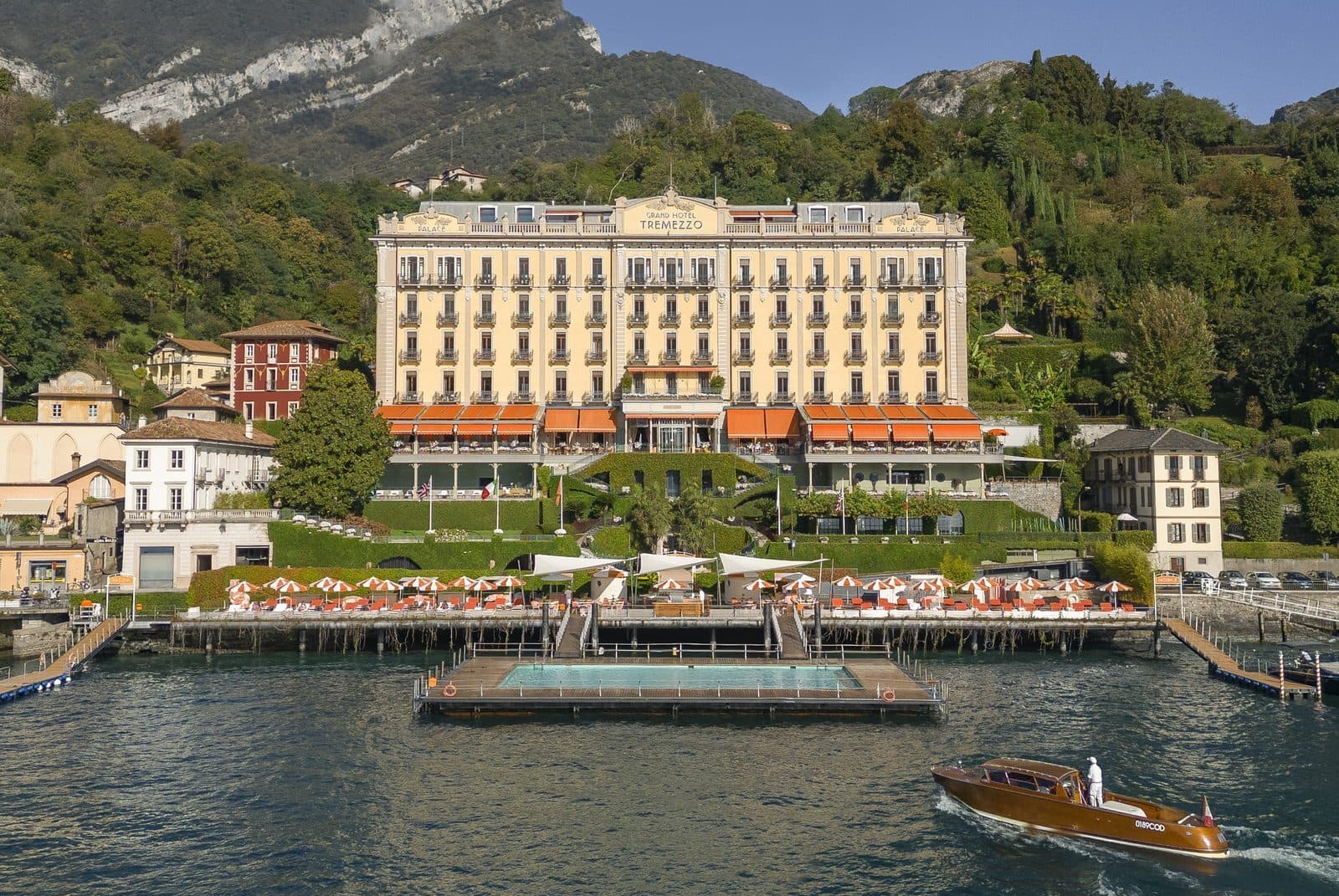 Grand Hotel Tremezzo on Lake Como, with a floating pool before the façade and a boat at the jetty