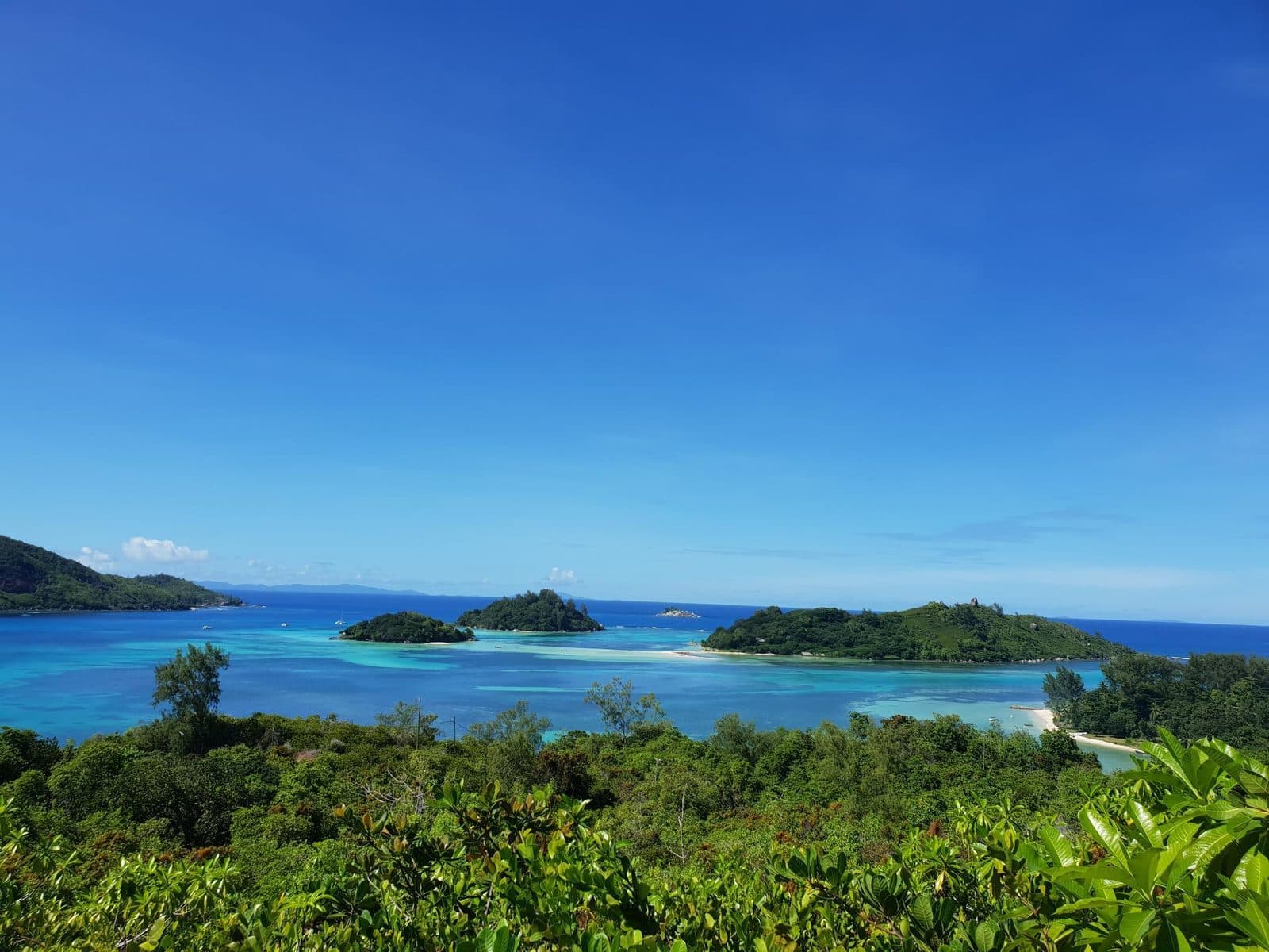 View from the hotel's helipad towards Sainte Anne Marine Park: turquoise water, green islets and vegetation on the hillside