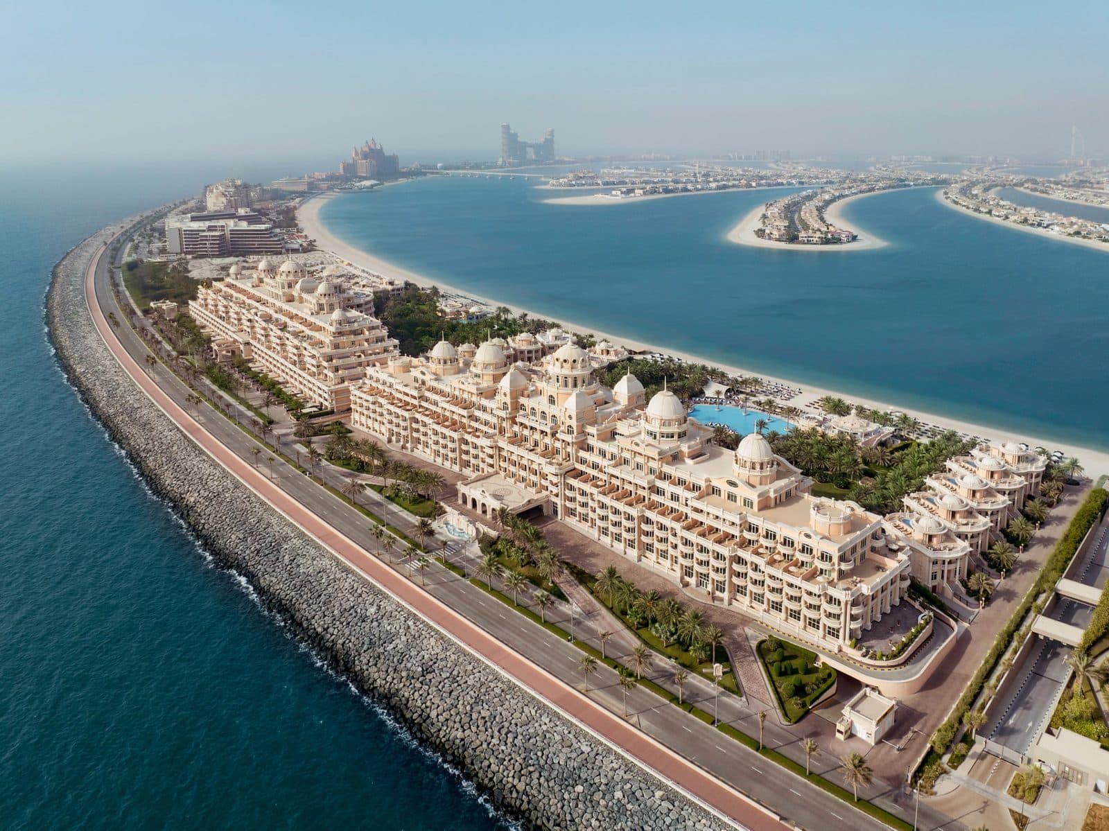 Aerial view of Raffles The Palm on the West Crescent: a domed palace, gardens and beach, with Palm Jumeirah’s crescents beyond